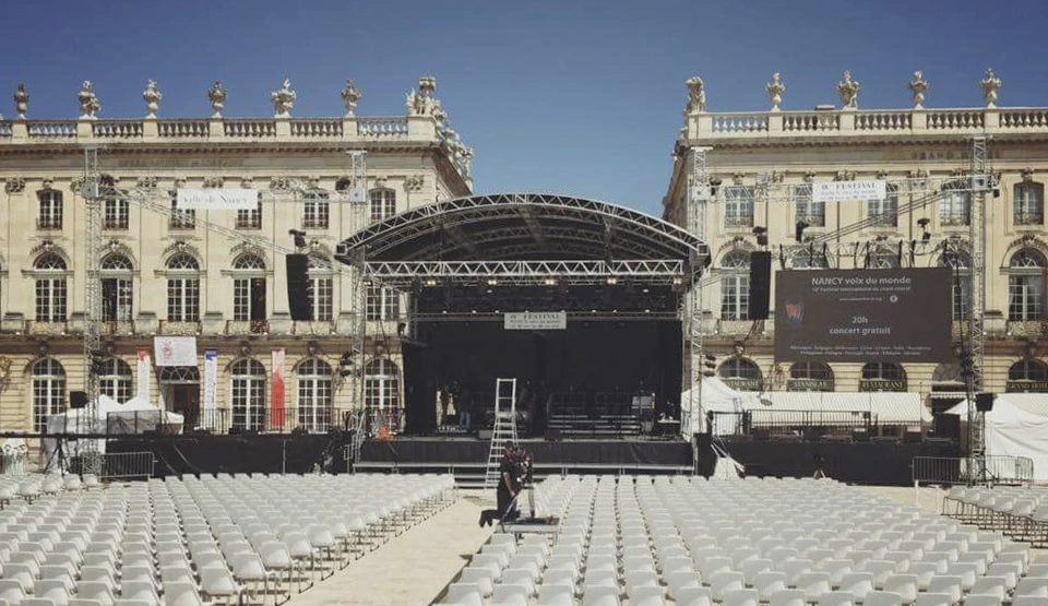Scène extérieure avec installation d'une scène de spectacle temporaire dans la cour d'un château classique français