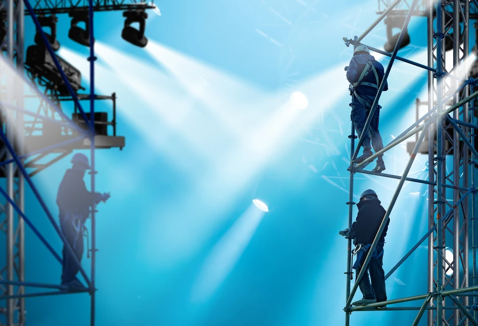 Sc&egrave;ne de concert vide avec &eacute;clairage professionnel bleu, projecteurs &agrave; t&ecirc;te mobile positionn&eacute;s sur la sc&egrave;ne, faisceaux lumineux crois&eacute;s cr&eacute;ant une atmosph&egrave;re spectaculaire dans une salle de spectacle