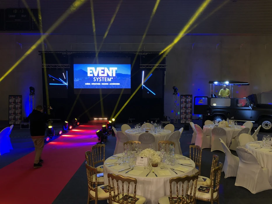 Scène extérieure d'un festival musical avec foule rassemblée devant une grande scène principale