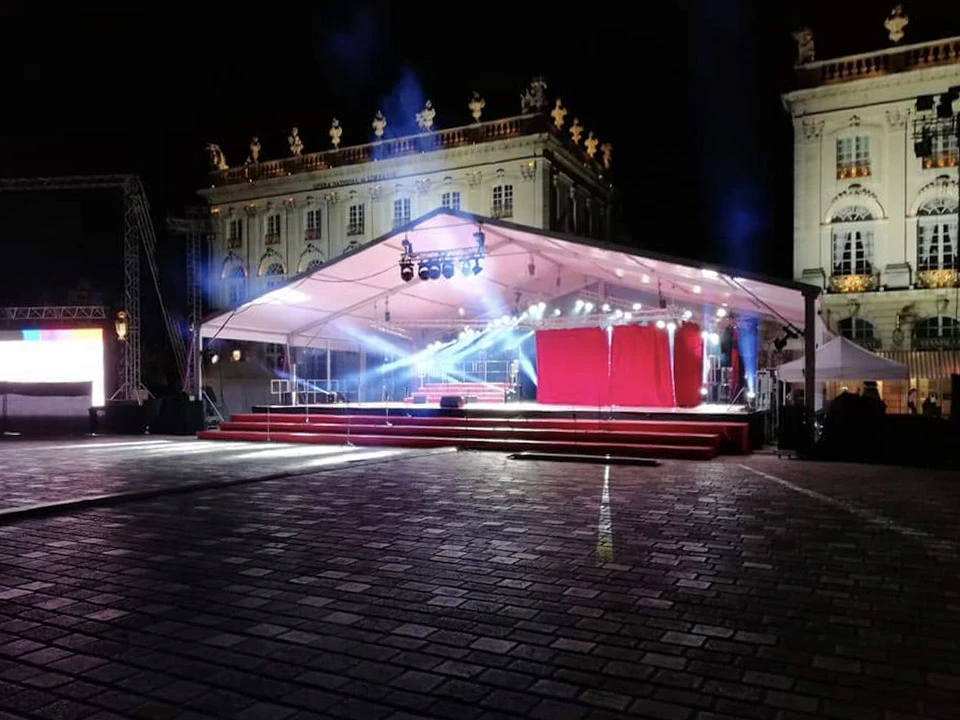 Scène extérieure d'une grande structure de concert temporaire installée sur pelouse