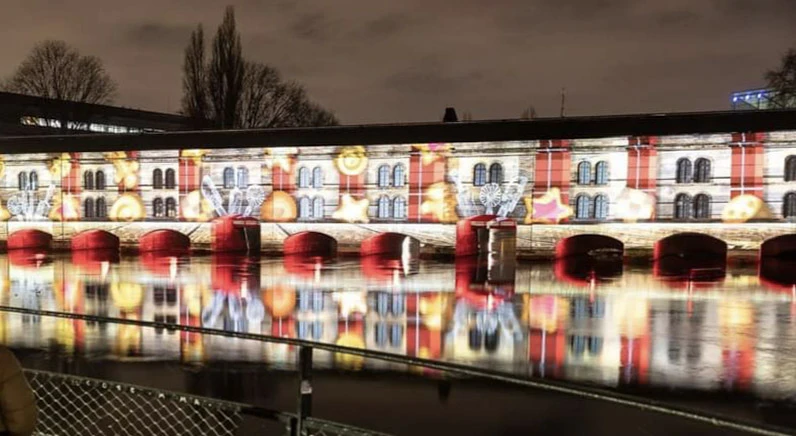 Scène extérieure de montage d'une scène de concert avec techniciens installant équipements audio et instruments