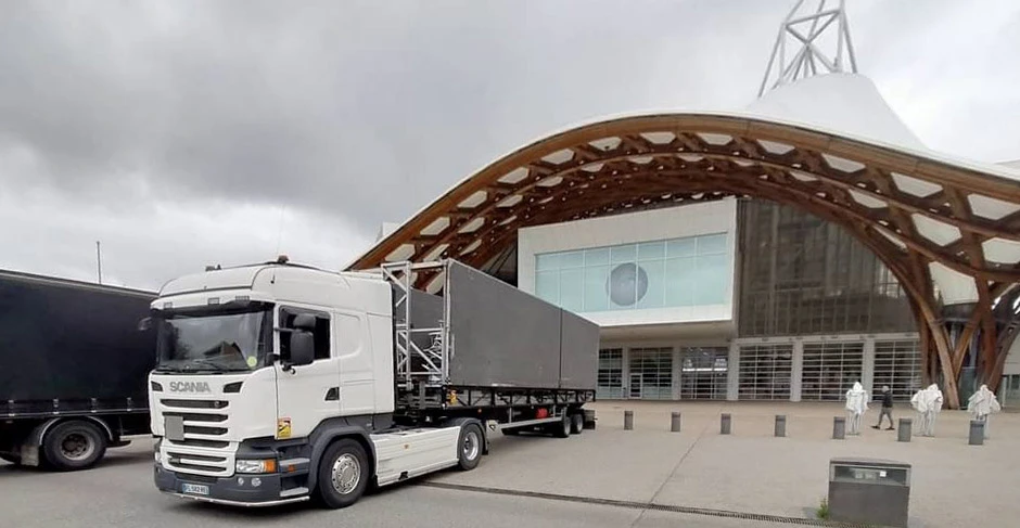 Concert en plein air avec scène équipée de structures truss métalliques, éclairage LED violet/magenta, système de sonorisation line array