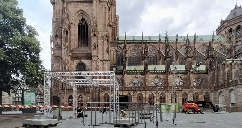 Scène de concert en préparation sous chapiteau avec techniciens effectuant le montage