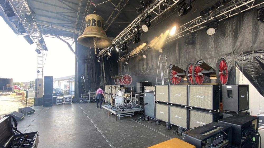 Scène de concert en préparation sous chapiteau avec techniciens effectuant le montage