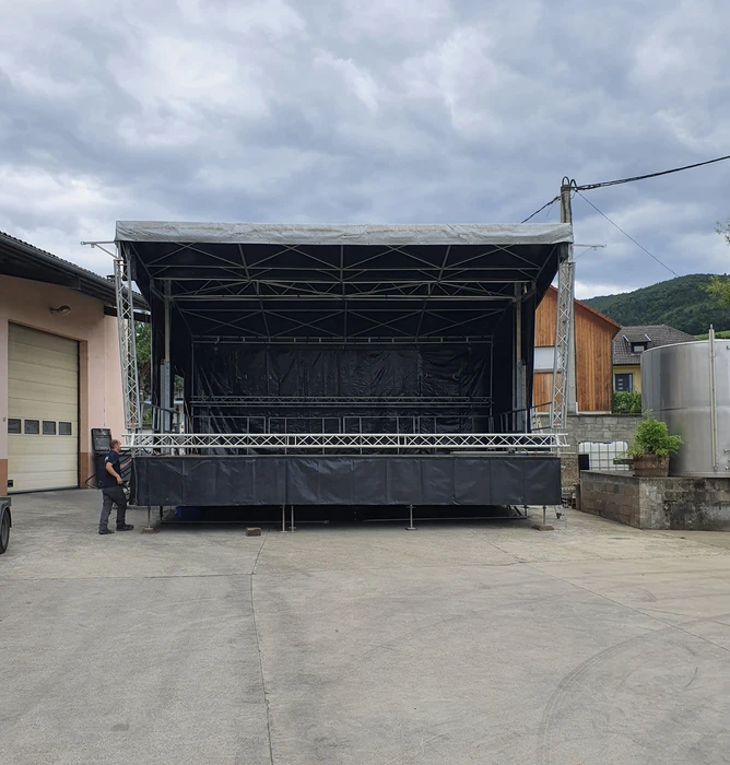Scène de concert en préparation sous chapiteau avec techniciens effectuant le montage