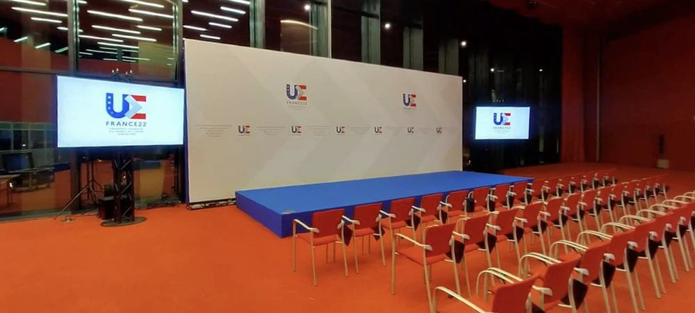 Salle de spectacle moderne avec scène centrale surélevée équipée d'éclairage professionnel et structure métallique