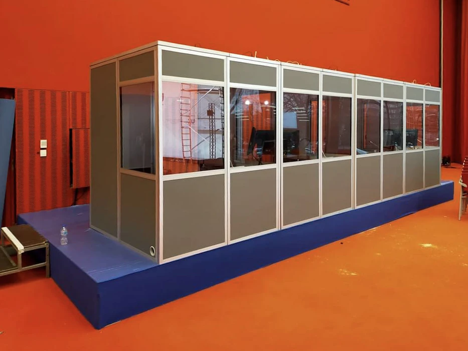 Scène extérieure de concert avec foule nombreuse face à une scène équipée d'écrans et structures métalliques