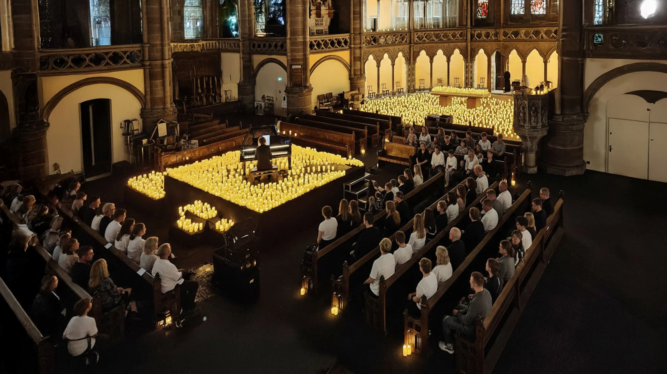 Concert en salle avec foule en liesse, mains lev&eacute;es vers la sc&egrave;ne
